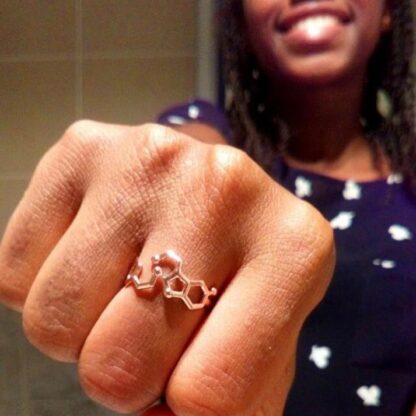 Serotonin dopamine ring rose gold shown into the camera by a female model