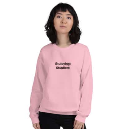 Woman wearing a pink sweatshirt with a Stu(dying) Stu(died) print