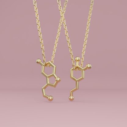 A serotonin and a dopamine molecule necklace in gold