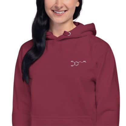 Model wearing a red hoodie with an embroidered dopamine molecule