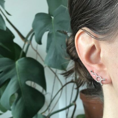 Dopamine molecule ear climber in silver worn by a model