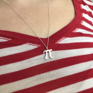 Small silver Pi necklace with a chain worn by a female model